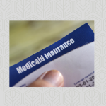 Medicaid Insurance card with thumb holding it
